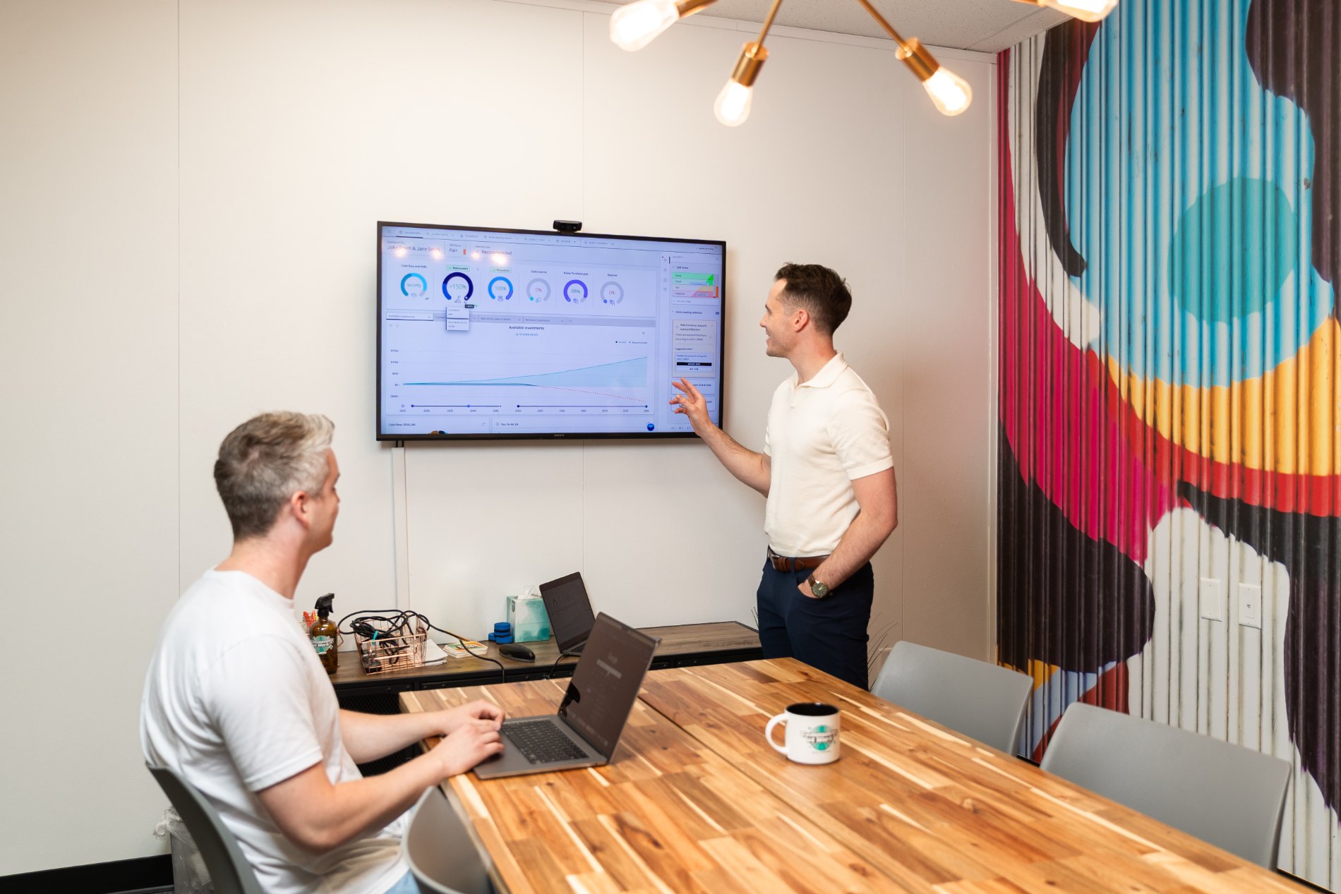 A Millen Wealth Advisors advisor walking a client through a planning dashboard during an in-office meeting.